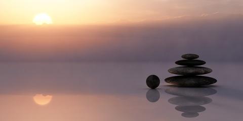 beach with sunrise and balanced stones