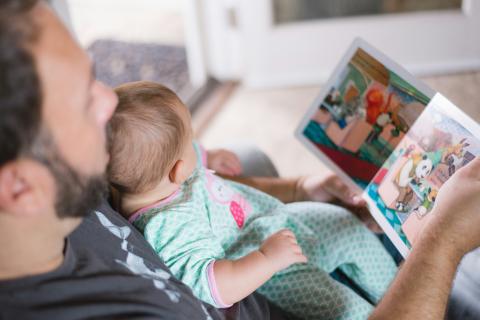 man reading book to baby